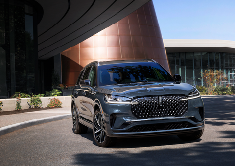 A gray 2025 Lincoln Aviator® SUV is parked outside a modern building with the sun shining. | Friendly Lincoln in Monroe MI