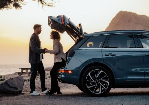 A couple share a moment together outside a 2025 Lincoln Corsair® SUV near the open liftgate. | Friendly Lincoln in Monroe MI