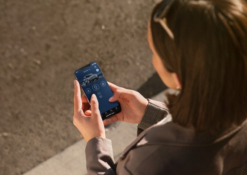 A person is shown interacting with a smartphone to connect to a Lincoln vehicle via the Lincoln Way® App. | Friendly Lincoln in Monroe MI