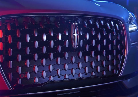 The grille of a 2025 Lincoln Corsair® SUV reflects neon light at night. | Friendly Lincoln in Monroe MI