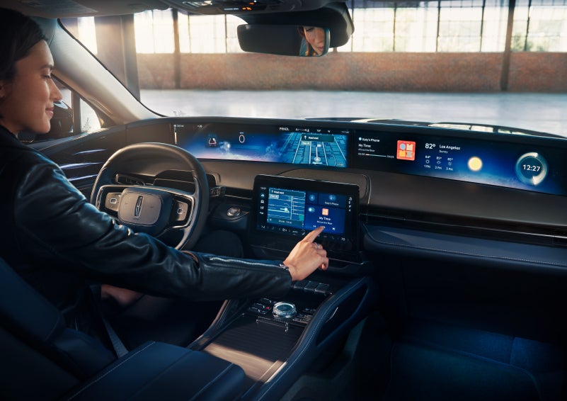 The driver of a 2025 Lincoln Nautilus® SUV interacts with the center touchscreen. | Friendly Lincoln in Monroe MI