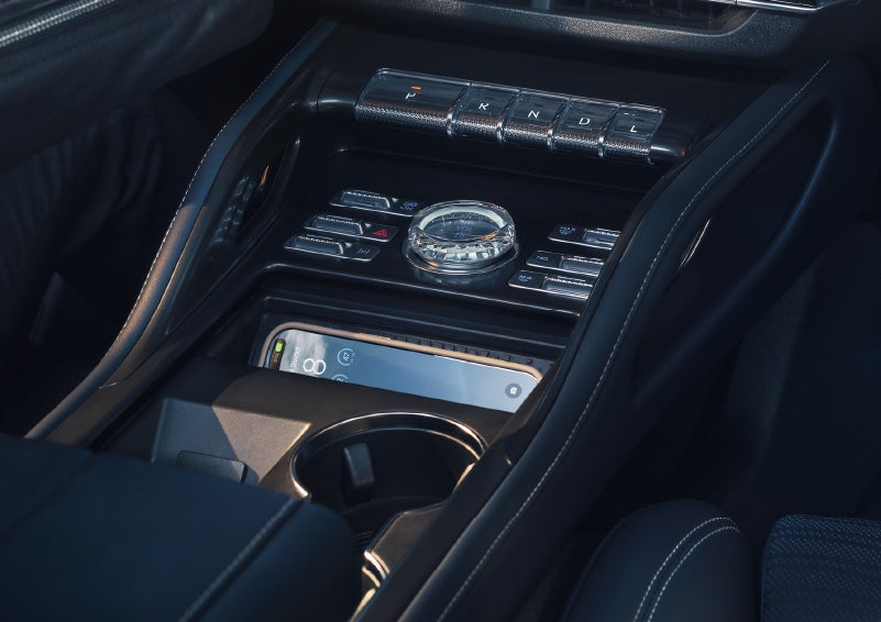 A smartphone is shown charging in the wireless charging pad. | Friendly Lincoln in Monroe MI