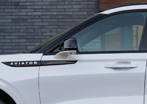 The driver’s side door and fender badging of a white 2026 Lincoln Aviator® SUV are showcased. | Friendly Lincoln in Monroe MI