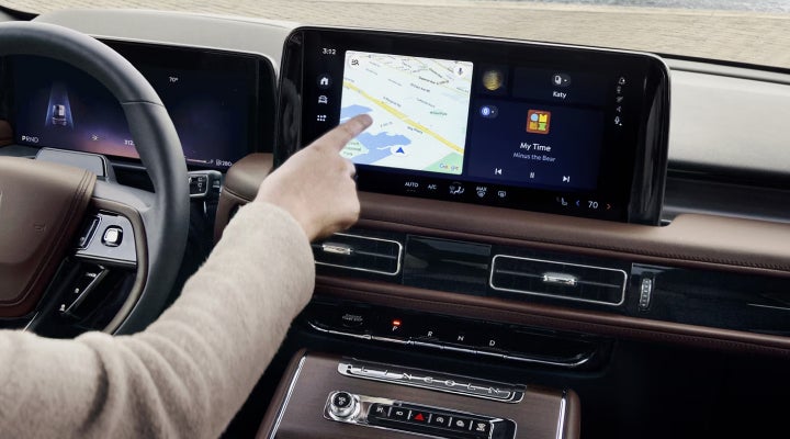 A person is tapping the center display touchscreen of a 2026 Lincoln Aviator® SUV. | Friendly Lincoln in Monroe MI