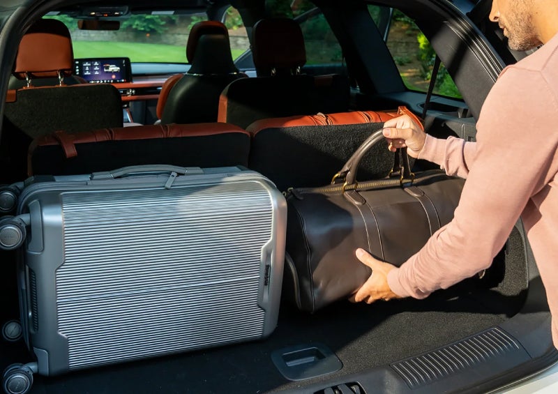 A man loads luggage into the rear of a 2026 Lincoln Aviator® SUV through the opened rear liftgate. | Friendly Lincoln in Monroe MI