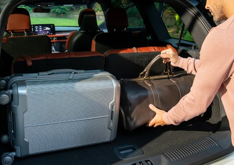 A man loads luggage into the rear of a 2026 Lincoln Aviator® SUV through the opened rear liftgate. | Friendly Lincoln in Monroe MI