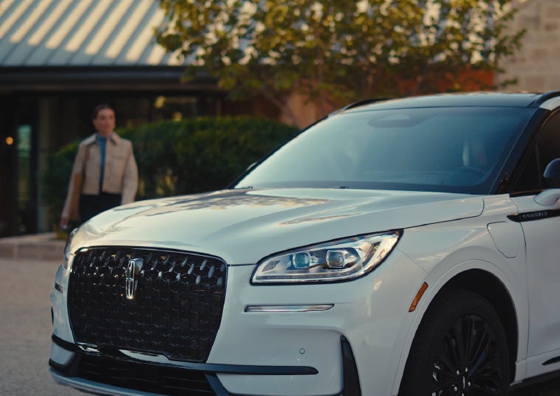 A person approaches a 2026 Lincoln Corsair® SUV as the Lincoln Embrace light sequence takes place. | Friendly Lincoln in Monroe MI