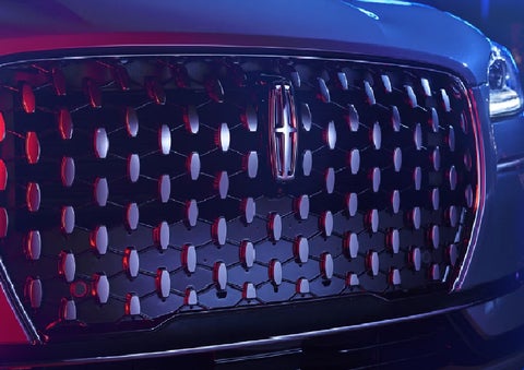 The grille of a 2025 Lincoln Corsair&reg; SUV reflects neon light at night. | Friendly Lincoln in Monroe MI