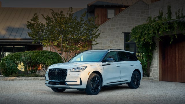 A 2026 Lincoln Corsair® SUV is parked in front off a luxury home. | Friendly Lincoln in Monroe MI