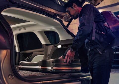 A man is shown loading cargo into the rear of a 2026 Lincoln Corsair® SUV with the second-row seats folded flat. | Friendly Lincoln in Monroe MI