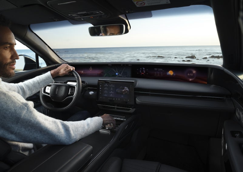 A driver of a parked 2026 Lincoln Nautilus® SUV takes a relaxing moment at a seaside overlook while inside his Nautilus. | Friendly Lincoln in Monroe MI