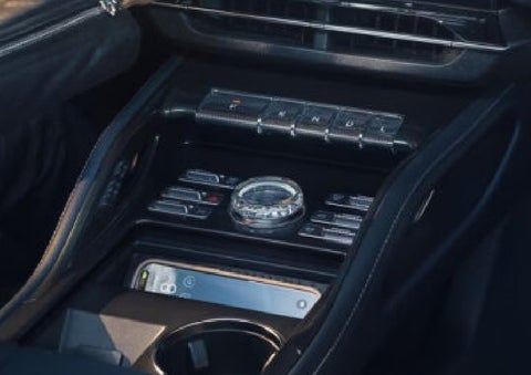 A smartphone is shown charging in the wireless charging pad. | Friendly Lincoln in Monroe MI