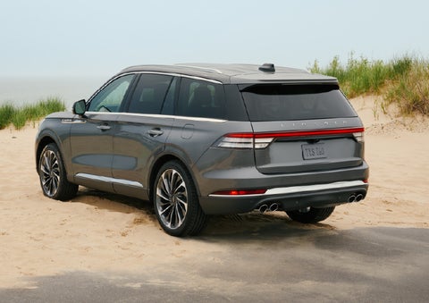 A 2027 Lincoln Aviator® SUV is parked next to sand dunes. | Friendly Lincoln in Monroe MI