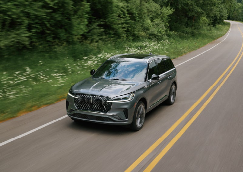 A 2027 Lincoln Aviator® SUV is being driven down a road. | Friendly Lincoln in Monroe MI