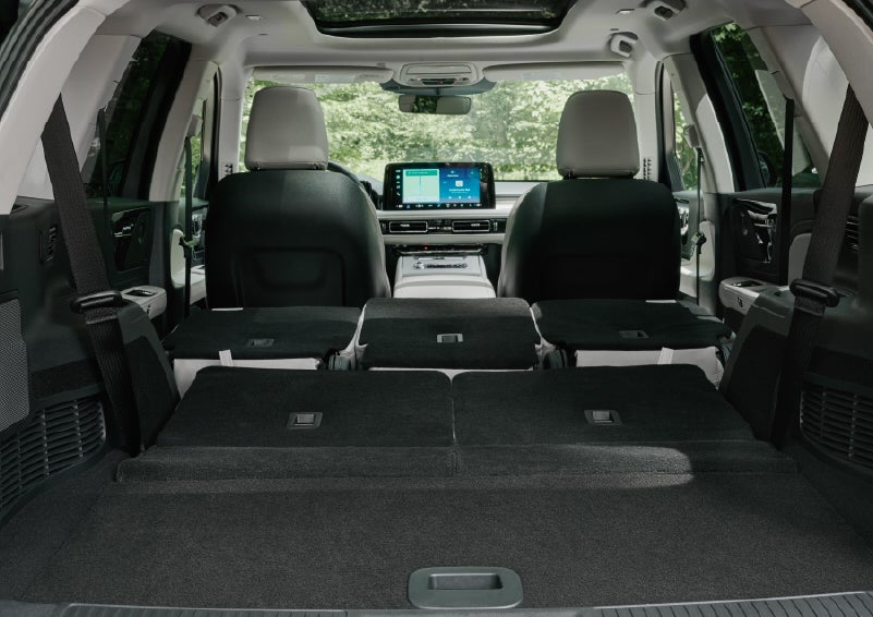 A rear to front view of the interior of a 2027 Lincoln Aviator® Black Label™ SUV shows the third and second rows folded flat | Friendly Lincoln in Monroe MI