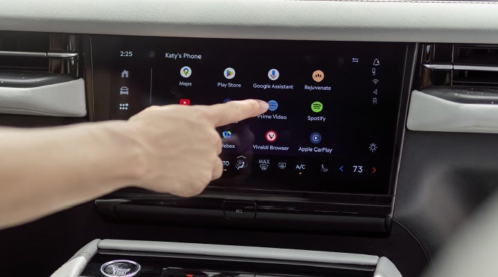 A person interacts with the center display of a 2027 Lincoln Navigator® SUV.