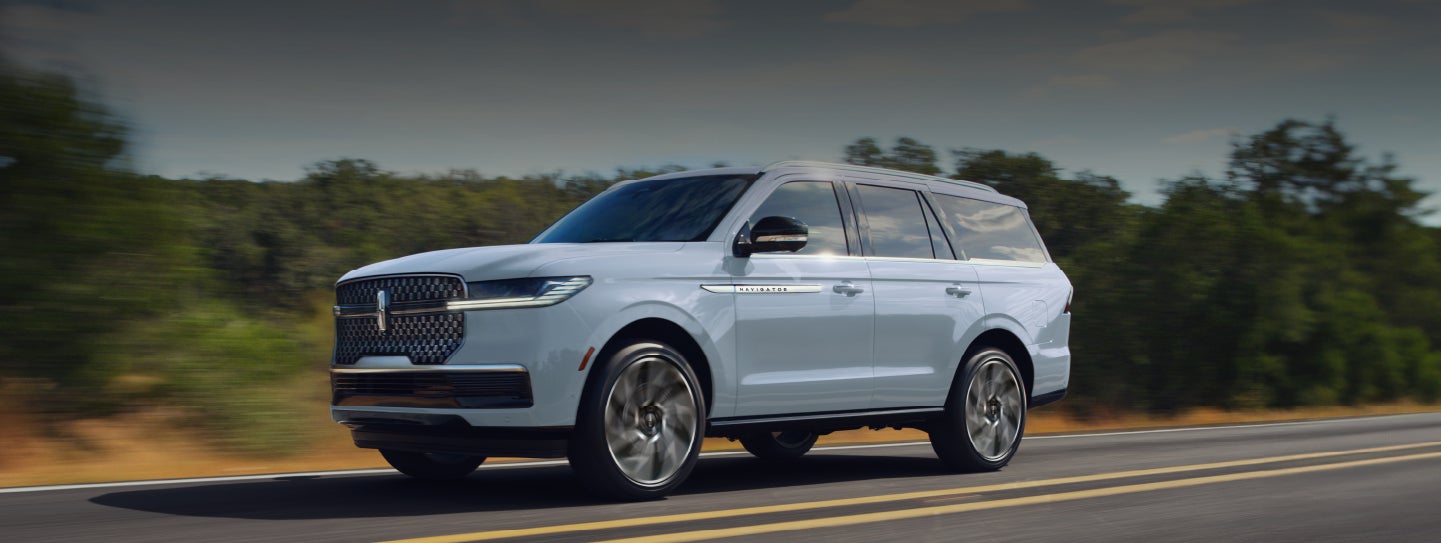 A 2027 Lincoln Navigator® SUV is being driven on a rural highway
