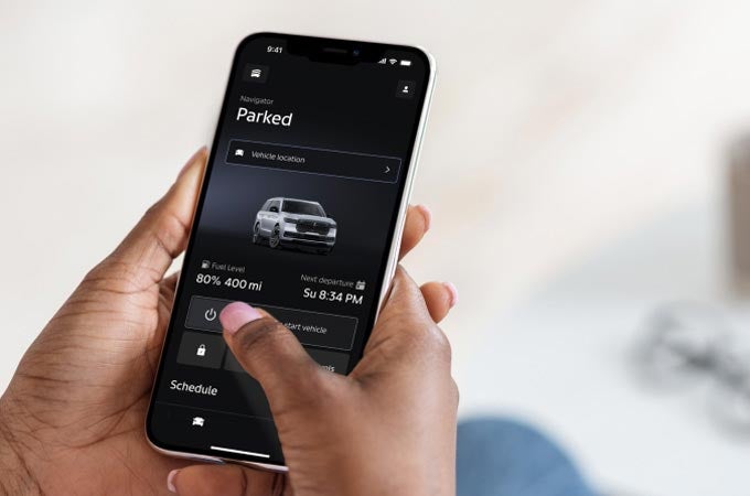 A woman holding a phone viewing the Lincoln app